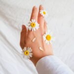 woman hand decorated with daisies