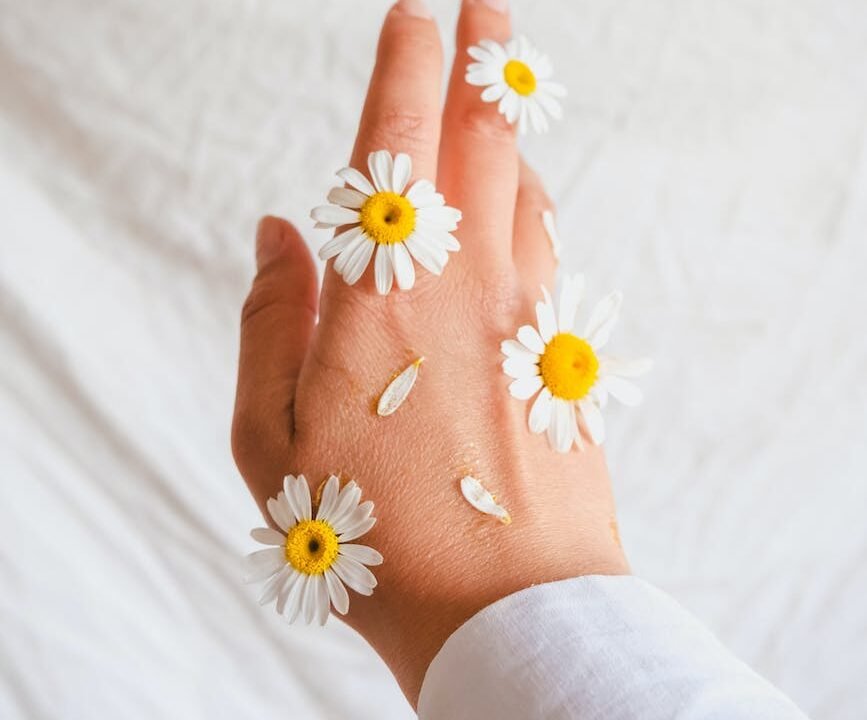 woman hand decorated with daisies