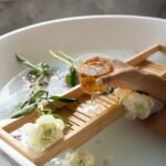 woman with wineglass and flowers in bathtub