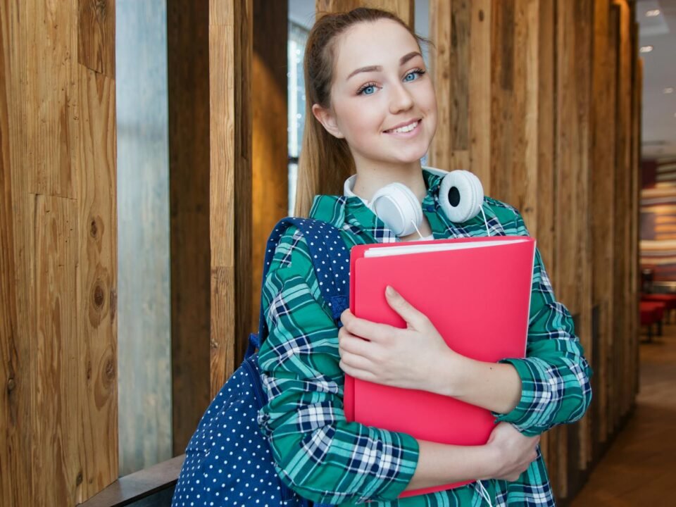 woman standing in hallway while holding book